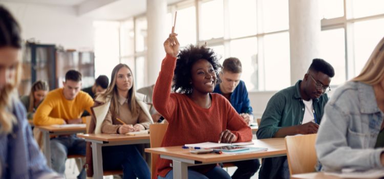 college student raises their hand in an accounting class